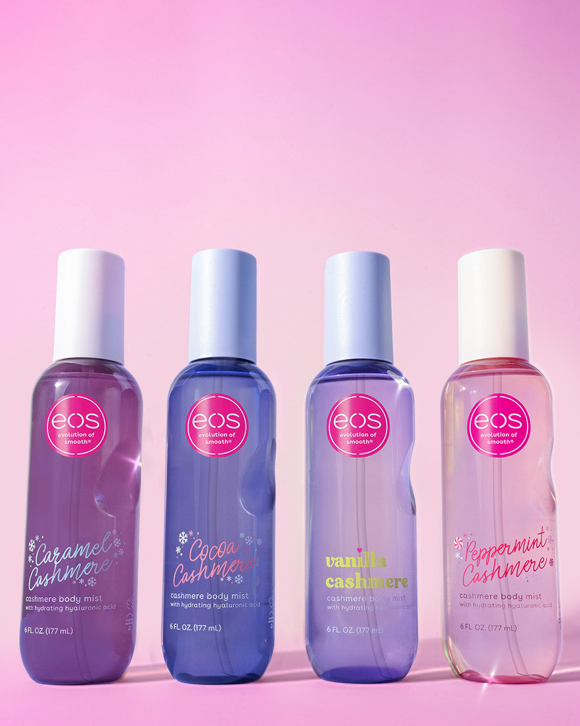 Four eos body mist bottles on a pink background